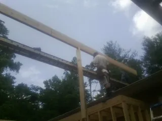 Carpenter setting a ridge beam over a new addition frame — Ice Dam Removal by Roofing Brothers in Dagsboro