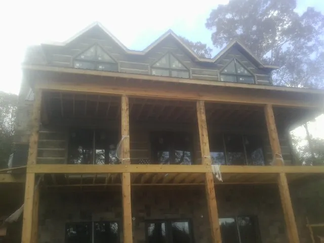 Dormers and porch framing on a large log home under construction — Roof Coating work by our crew in Dagsboro
